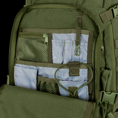 The Condor Venture Backpack 27.5L in green is shown open, revealing multiple mesh and fabric interior pockets, compartments, an elastic strap, and a plastic clip for organized storage.
